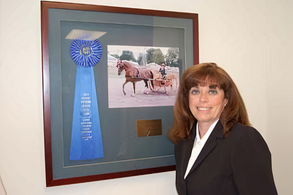 photo of attorney Glavin with an award and picture of her horse 